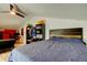 Bedroom features ceiling fan, personal storage, blue comforter, and a red accent wall with a gaming system at 7320 Hideaway Trl, New Port Richey, FL 34655