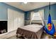 Bright bedroom with white closet doors, ceiling fan, and decorative wall hangings, with wood-look vinyl floors at 7320 Hideaway Trl, New Port Richey, FL 34655