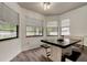 Bright dining area features wood-look floors, a dark wood table with booth seating and natural light from multiple windows at 7320 Hideaway Trl, New Port Richey, FL 34655