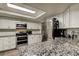 Bright kitchen featuring white cabinets, granite countertops, and stainless steel appliances at 7320 Hideaway Trl, New Port Richey, FL 34655