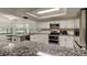 A modern kitchen boasts white cabinets, granite countertops, and stainless steel appliances at 7320 Hideaway Trl, New Port Richey, FL 34655