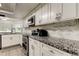 Modern kitchen featuring granite countertops, stainless steel appliances, and stylish backsplash at 7320 Hideaway Trl, New Port Richey, FL 34655