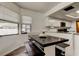Kitchen and dining area feature granite countertops, a dark wood dining table and white cabinets and a stainless steel microwave at 7320 Hideaway Trl, New Port Richey, FL 34655