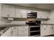 Kitchen featuring white cabinets, granite countertops, stainless appliances, and subway tile backsplash at 7320 Hideaway Trl, New Port Richey, FL 34655