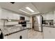 A bright kitchen showcases white cabinets, granite countertops, and stainless steel appliances at 7320 Hideaway Trl, New Port Richey, FL 34655