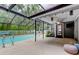 Screened-in pool featuring a patio, outdoor seating, and a lush tropical garden at 7320 Hideaway Trl, New Port Richey, FL 34655