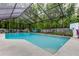 Large inground pool surrounded by a screened enclosure and lush greenery at 7320 Hideaway Trl, New Port Richey, FL 34655