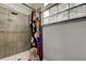 Shower features a shower head, shower curtain, and grey tile walls with a white tile floor at 7320 Hideaway Trl, New Port Richey, FL 34655