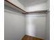 A well-lit closet featuring hardwood floors and sturdy wooden shelving and hanging rods at 7814 Judith Cres, Port Richey, FL 34668