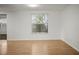Bright living room featuring wood floors and a large window, perfect for relaxation and entertaining at 7814 Judith Cres, Port Richey, FL 34668