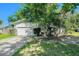 View of a well-kept single-story home featuring a two-car garage and front yard landscaping at 801 Lamont Pl, Temple Terrace, FL 33617