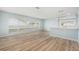 Bright living area featuring wood-look flooring, large windows, and an open layout to the kitchen at 801 Lamont Pl, Temple Terrace, FL 33617