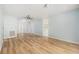 Bright living room showcasing wood-look flooring, a ceiling fan, and access to the kitchen and entryway at 801 Lamont Pl, Temple Terrace, FL 33617