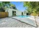 A private pool area features a fence, backyard trees, light gray concrete pool deck and white rock at 801 Lamont Pl, Temple Terrace, FL 33617