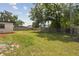 Spacious backyard with mature trees and a wooden fence, offering privacy and a great space for outdoor activities at 8108 Fir Dr, Tampa, FL 33619