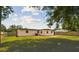 Large, fenced backyard with green grass and trees providing shade, ideal for relaxation and outdoor enjoyment at 8108 Fir Dr, Tampa, FL 33619