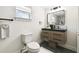 Contemporary bathroom with modern vanity, toilet, dark fixtures, and a framed mirror at 8108 Fir Dr, Tampa, FL 33619