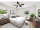 Well-lit bedroom with neutral tones, complete with a ceiling fan and a cozy seating area at 8108 Fir Dr, Tampa, FL 33619