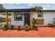 Charming home featuring a new front door, stylish accents, and well-manicured landscaping at 8108 Fir Dr, Tampa, FL 33619