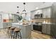 Spacious kitchen featuring modern stainless steel appliances, bar seating, and hardwood floors at 8108 Fir Dr, Tampa, FL 33619