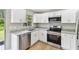 Modern kitchen with stainless steel appliances, granite countertops, and white cabinets at 9936 62Nd N St, Pinellas Park, FL 33782