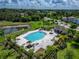 Overhead view of a community pool with palm trees, outdoor seating, and surrounding neighborhood landscape at 10119 Rose Petal Pl, Riverview, FL 33578
