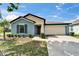 Single-story home featuring a two-car garage, blue paint, and manicured landscaping at 10119 Rose Petal Pl, Riverview, FL 33578