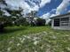 Expansive green backyard, with a tree and view of the back of the home at 1106 Trellis Ave, Spring Hill, FL 34606