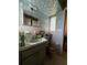 Bathroom featuring light green sink vanity, linoleum floors and floral wallpaper at 1106 Trellis Ave, Spring Hill, FL 34606