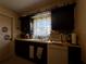 Compact kitchen with dark cabinets and white appliances at 1106 Trellis Ave, Spring Hill, FL 34606