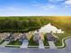 An aerial daytime view of a community of homes, with a pond and treelined backdrop at 11597 Weaver Hollow Rd, New Port Richey, FL 34654