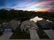 Sunset aerial view of a well maintained home backing up to a pond and a forest at 11597 Weaver Hollow Rd, New Port Richey, FL 34654