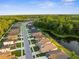 Aerial view of a neighborhood, showcasing houses, streets, a lake, and lush green trees at 11597 Weaver Hollow Rd, New Port Richey, FL 34654