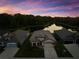 Aerial shot of a single Gathering home on a pond with treelined backdrop during the evening at sunset at 11597 Weaver Hollow Rd, New Port Richey, FL 34654