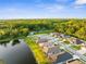 Aerial view of a lakeside community, showing modern homes with neatly manicured lawns and a lush, green forest backdrop at 11597 Weaver Hollow Rd, New Port Richey, FL 34654