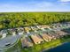 Aerial shot showing rooftops of homes lining a street, nestled beside a tree-lined lake with a forest backdrop at 11597 Weaver Hollow Rd, New Port Richey, FL 34654