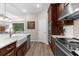 Open-concept kitchen featuring stainless steel appliances, farmhouse sink, and seamless flow to the living area at 11597 Weaver Hollow Rd, New Port Richey, FL 34654