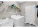 Functional laundry room with a utility sink, washer, dryer and overhead shelving for ample storage at 11597 Weaver Hollow Rd, New Port Richey, FL 34654