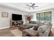 Spacious living room with large sectional sofa, fireplace, ceiling fan, and view of the backyard at 11597 Weaver Hollow Rd, New Port Richey, FL 34654