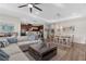 Open-concept living room with kitchen and dining area, featuring wood floors and stylish decor at 11597 Weaver Hollow Rd, New Port Richey, FL 34654