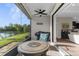 Screened patio with ceiling fan, outdoor furniture, and a peaceful view of the lake and trees at 11597 Weaver Hollow Rd, New Port Richey, FL 34654