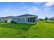 A view of a backyard with green grass and a screened-in porch perfect for relaxing and enjoying the outdoors at 11940 Stone Pine St, Riverview, FL 33569