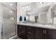 Bathroom showcasing double sinks with dark cabinets, granite countertops, and a glass-enclosed shower at 11940 Stone Pine St, Riverview, FL 33569