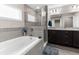 Bathroom featuring a soaking tub with gray tiled surround, glass shower, and double vanity at 11940 Stone Pine St, Riverview, FL 33569
