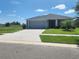 Charming single-story home with a well-manicured lawn, grey exterior, and an attached two-car garage at 11940 Stone Pine St, Riverview, FL 33569