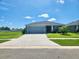 Charming single-story home with a well-manicured lawn, grey exterior, and an attached two-car garage at 11940 Stone Pine St, Riverview, FL 33569