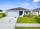 Charming single-story home features a well-manicured lawn and attached two-car garage at 11940 Stone Pine St, Riverview, FL 33569