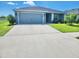 Inviting single-story home with a spacious driveway, two-car garage, and beautifully manicured front lawn at 11940 Stone Pine St, Riverview, FL 33569