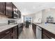 Modern kitchen featuring stainless steel appliances, dark cabinets, an island, and stylish pendant lighting at 11940 Stone Pine St, Riverview, FL 33569
