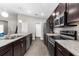 Spacious kitchen features stainless steel appliances, dark cabinets, ample counter space, and modern flooring at 11940 Stone Pine St, Riverview, FL 33569
